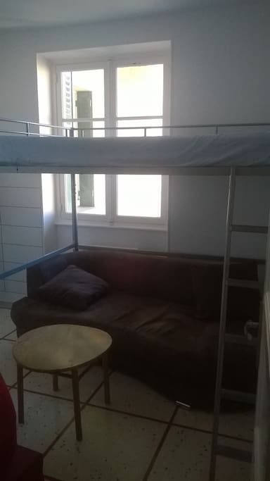Chambre avec lit mezzanine, canapé et table basse