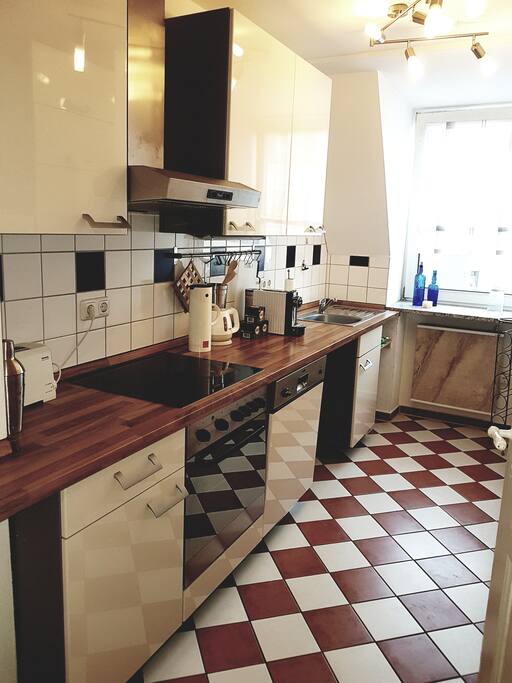 Küche mit Kühlschrank, Spülmaschine, Kaffeemaschine, Toaster, Wasserkocher und Cerankochfeld