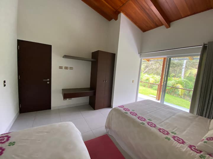 Dormitorio con cama queen y cama de plaza y media. Terraza con vista a jardín y sonido del río.