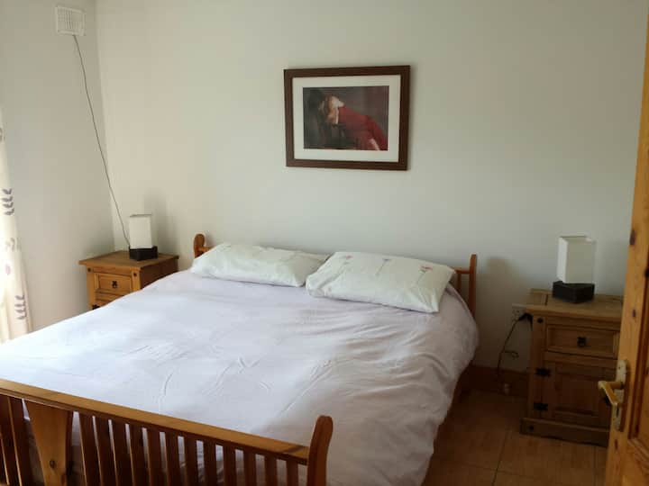 Dormitorio grande y luminoso con cama tamaño súper king. 