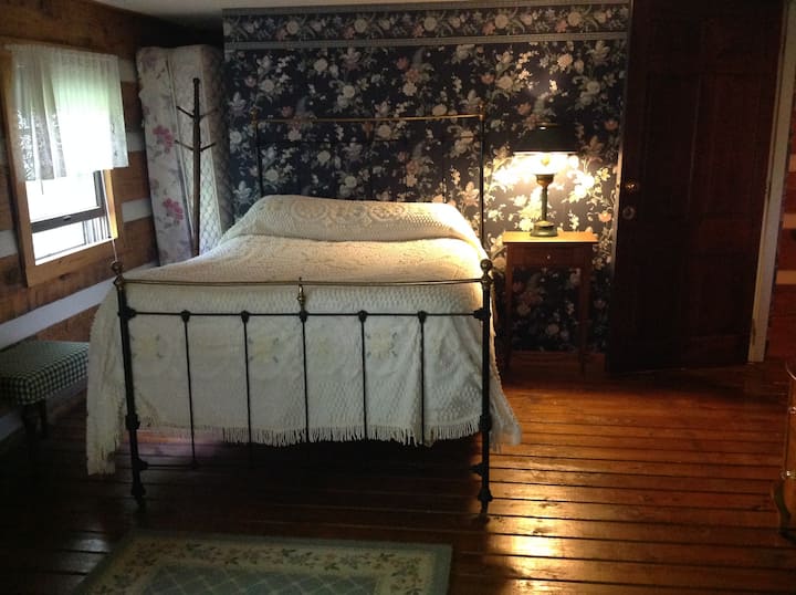 Second bedroom area includes attractive full size iron and brass bed with a feather ticking.