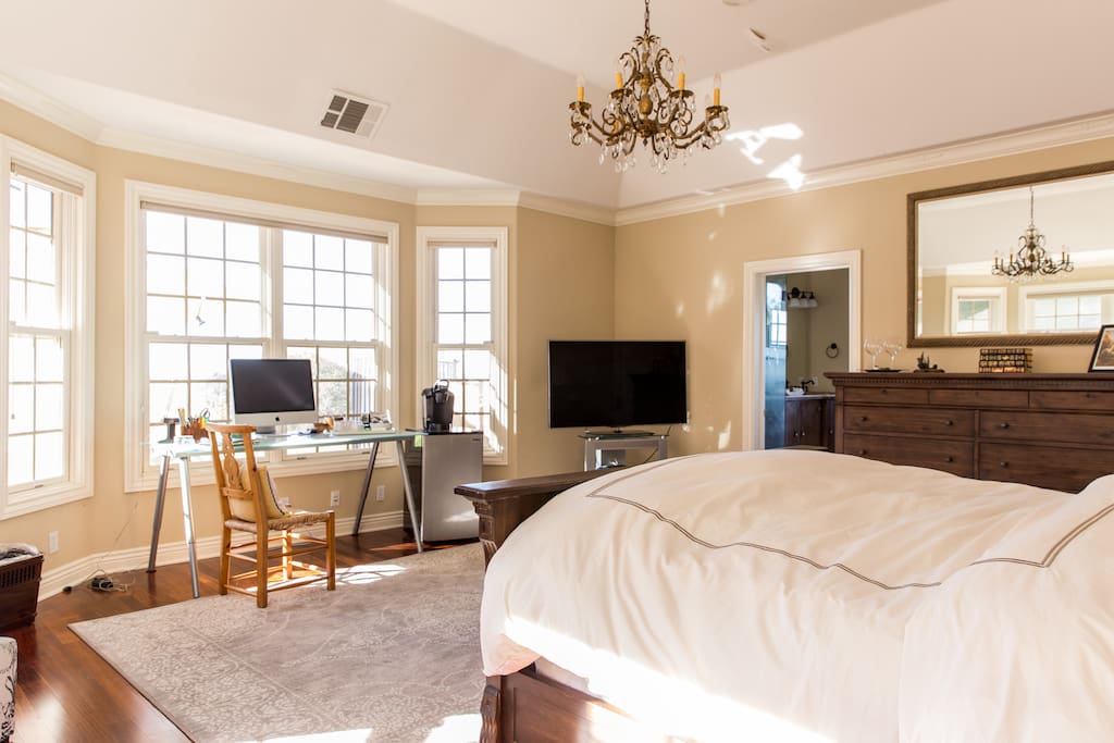 Master suite with smart tv and expansive private view of the expansive back pool area.