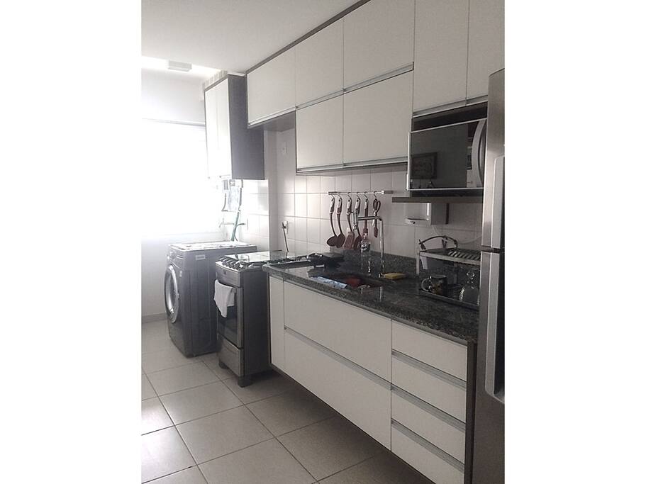 Cozinha e Área de Serviço equipada com geladeira, fogão 4 bocas, micro-ondas, maquina de lavar louça, tanque, filtro de água