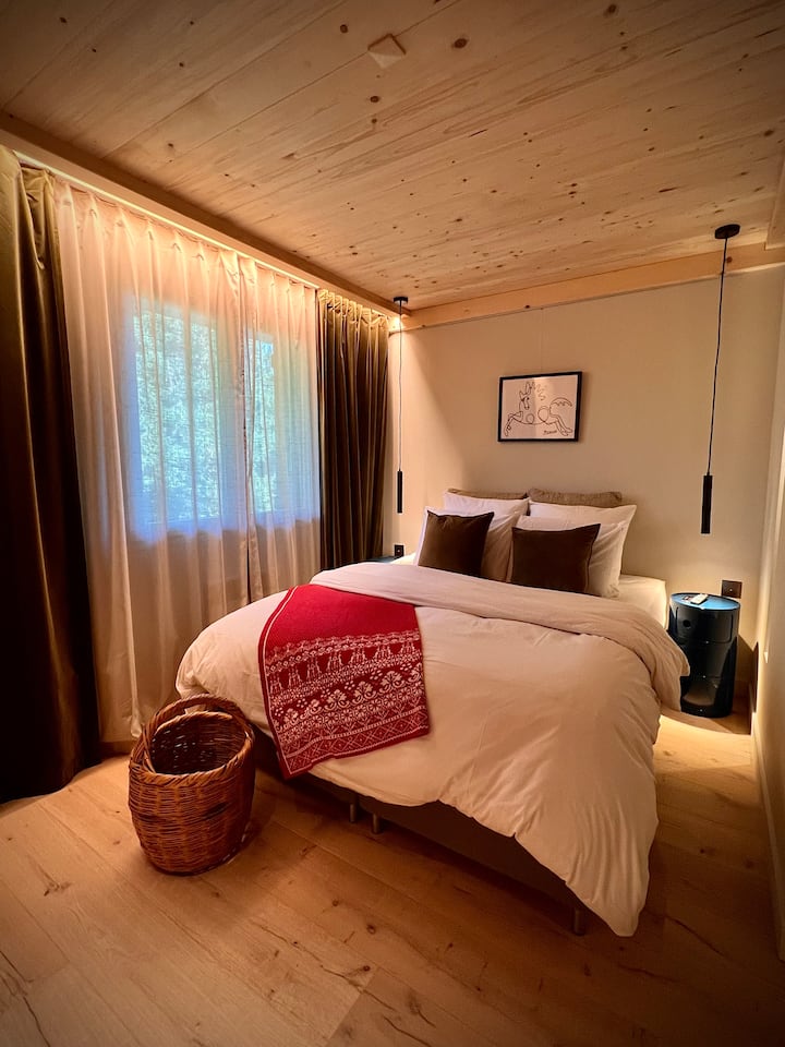 Chambre avec lit de 160x200cm
Coussins de diverses textures à choix 
Tables de chevet Kartel et lampes de chevet pendantes pilotables depuis le lit
Prises et interrupteurs en nickel brossé