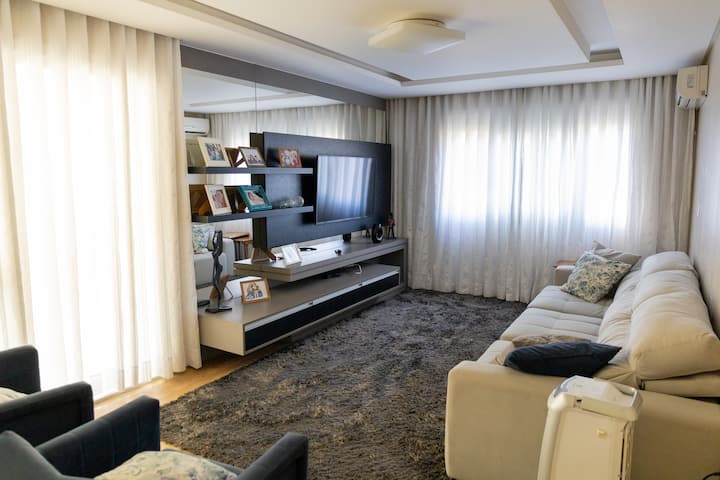 غرفة معيشة بها أريكة وسرير واحد. مع Netflix وتكييف الهواء