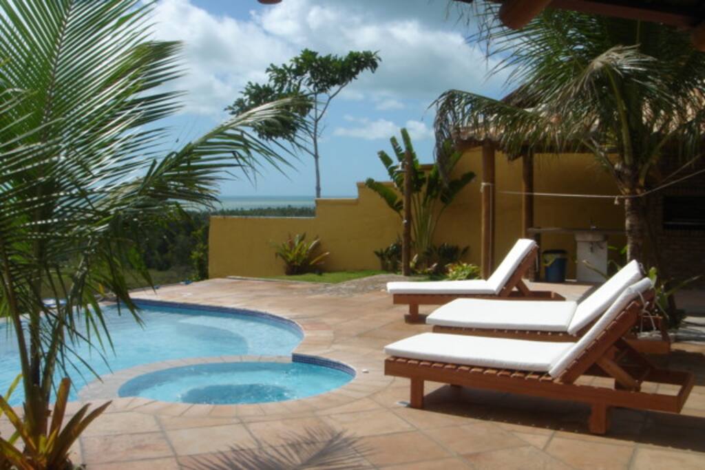 Sunbath by the infinity pool overlooking the rain-forest and ocean