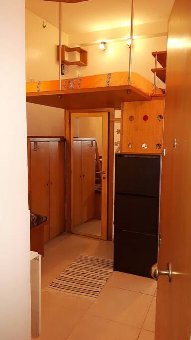 Ed ecco il monolocale visto dalla porta di ingresso della casa.
Ampio armadio a sinistra,per riporre i vostri vestiti. Letto sul soppalco e porta del bagno con specchio.Here is the studio seen from the front door of the house. Large wardrobe on the left to store your clothes. Bed on the mezzanine and bathroom door with mirror.