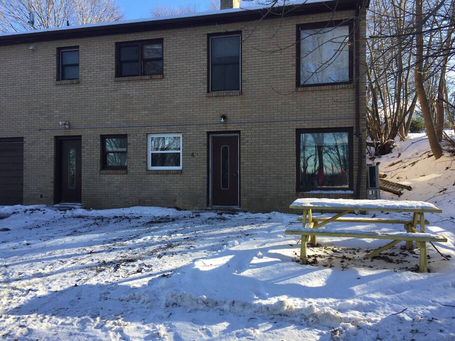 Front view of house with door, picnic table, and front yard.