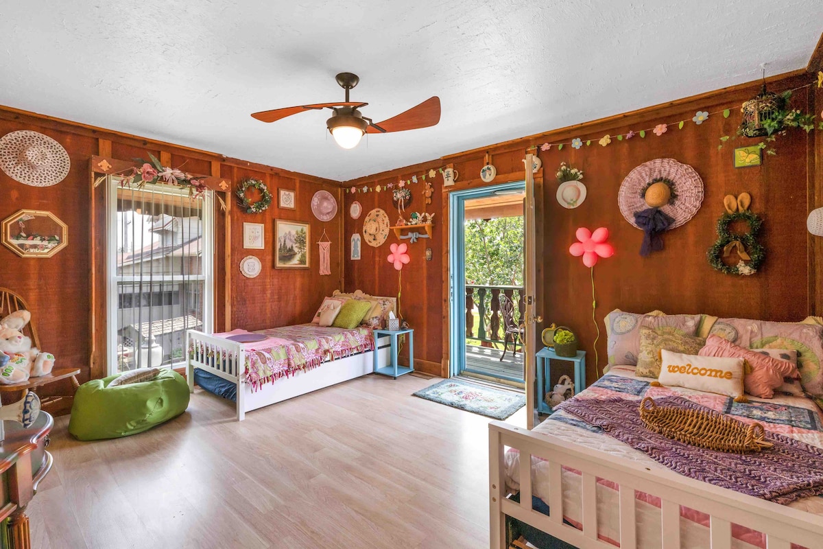 This room features two twin beds, each containing their own additional twin bed underneath. Door leads to beautiful outdoor front balcony.