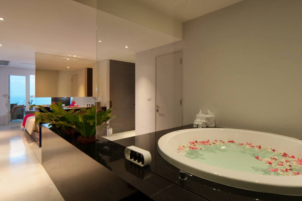 A big round bathtub connect to bedroom
