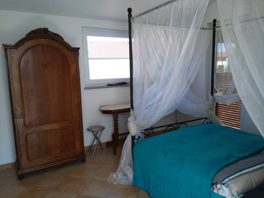 Conopy bed with an antique wardrobe