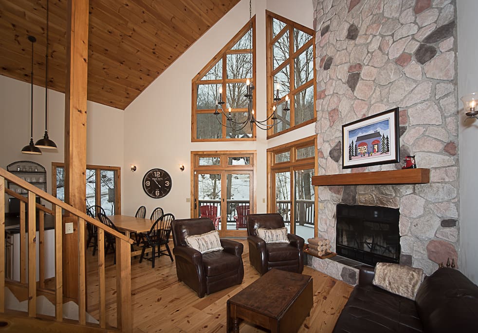 Living room with vaulted ceiling, wood-burning fireplace, gorgeous mountain views and plenty of space for entertaining!