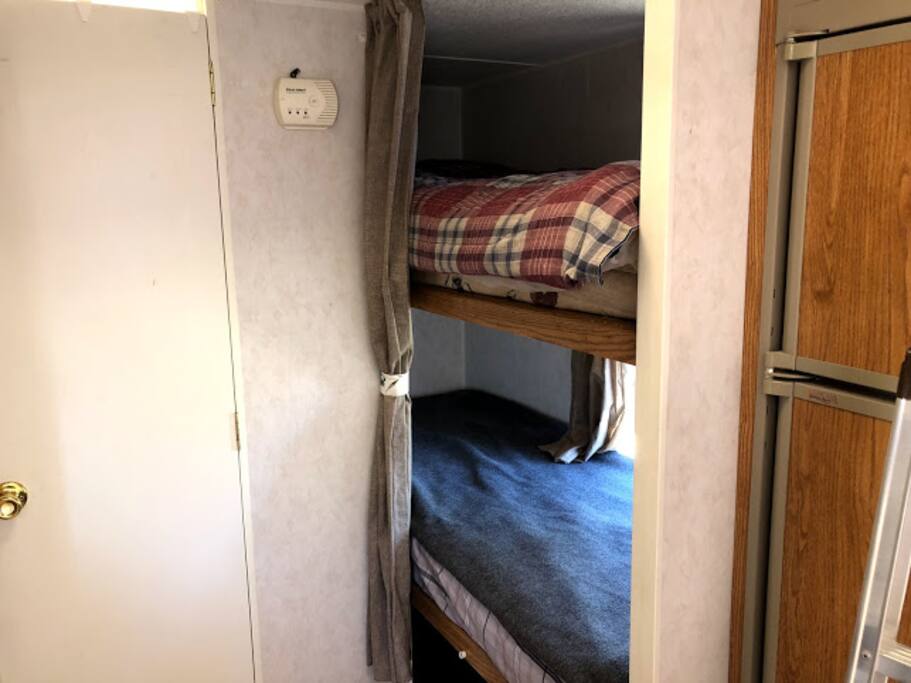 Three tier bunk bed with personal windows and bedside lights.