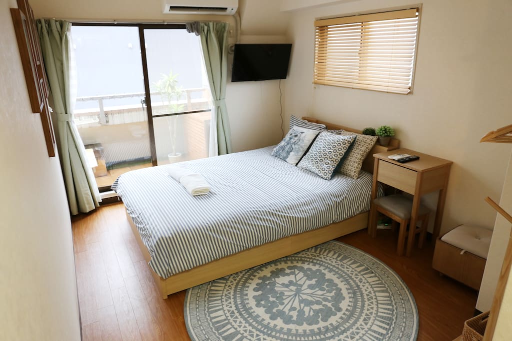 Bedroom with attached balcony, TV, beauty table for the ladies, and floor space for casual dining