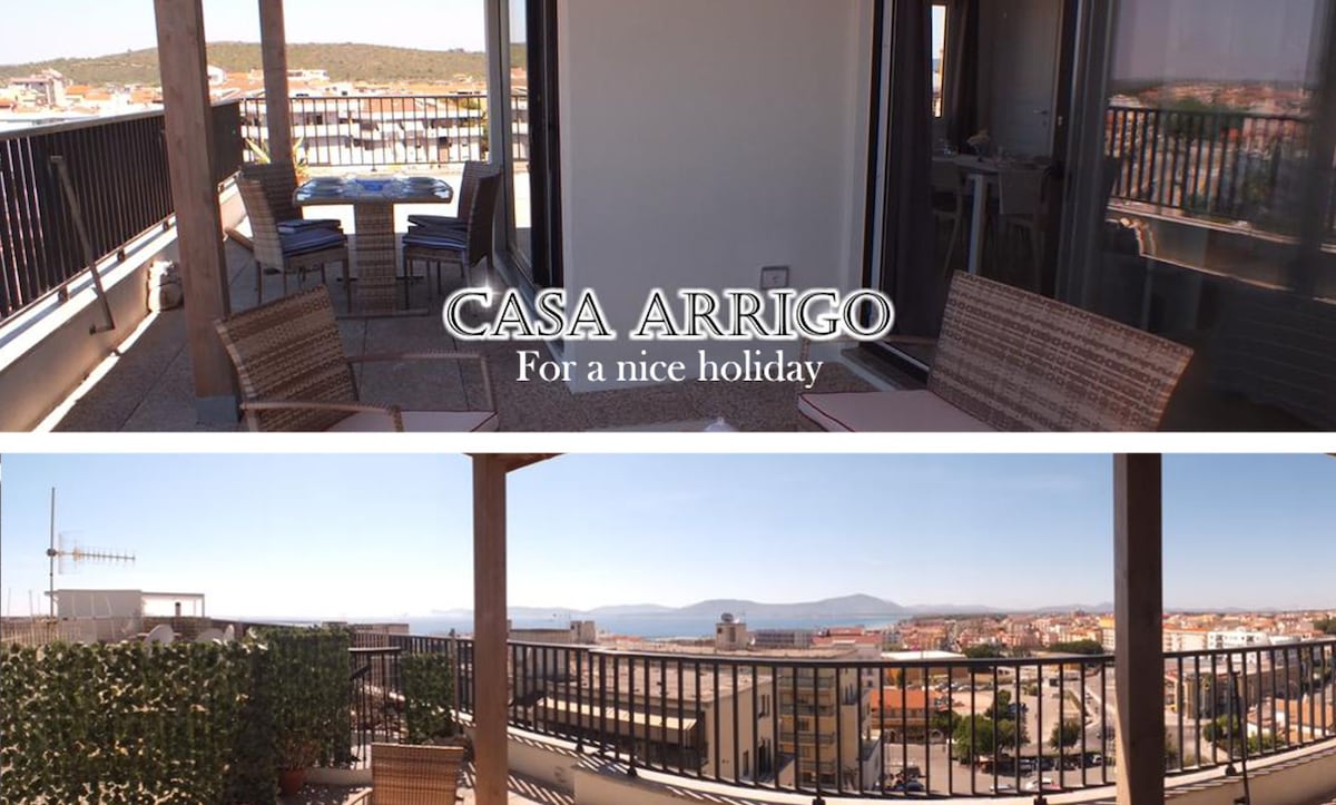 A spacious terrace offers panoramic views of the surrounding city and sea. Comfortable seating arrangements are provided, allowing for relaxation while enjoying the landscape. The terrace is partially shaded and features outdoor dining options that invite leisurely meals.