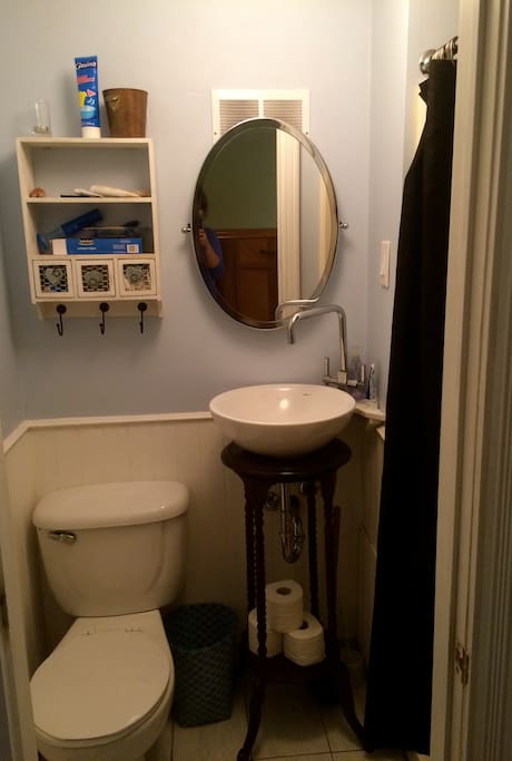Small bathroom with shower, towels, hairdryer, first aid