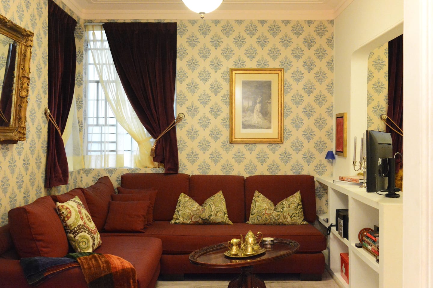 best airbnb mexico city condesa and roma norte | Vintage style living room with burgundy sofa and wallpaper