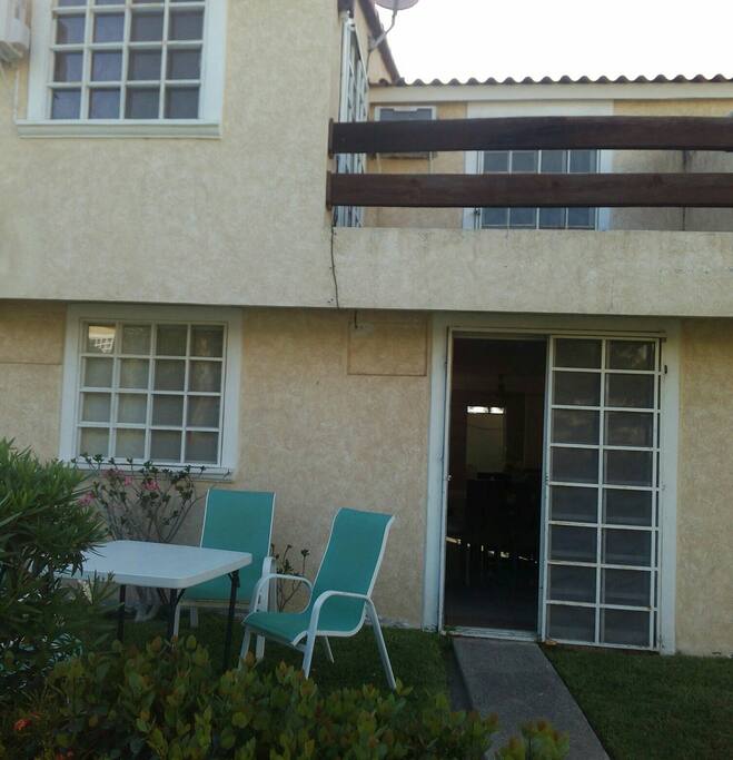 la parte trasera de la casa y se aprecia el balcón