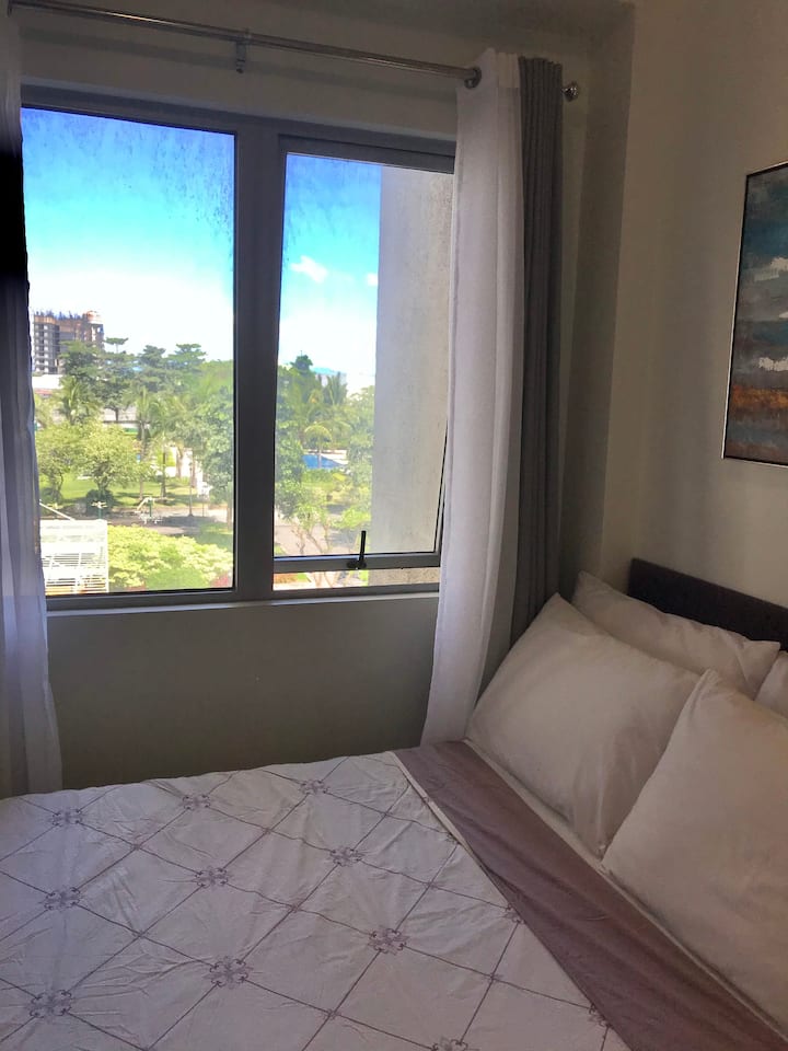 إطلالة من غرفة النوم الأولى. يمكن رؤية الأشجار المزروعة بالكامل وجزء من حمام السباحة في النادي من هنا.