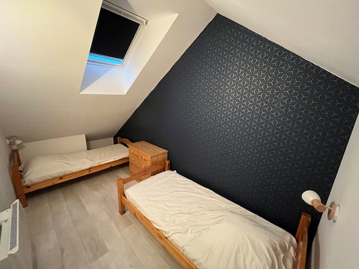 Chambre à l’étage, pourvue de deux lits simples.