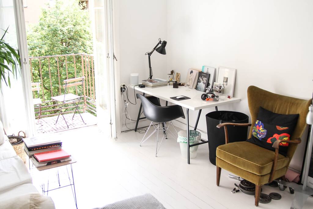 Big room with balcony, bed, sofa, wardrobe and desk.
