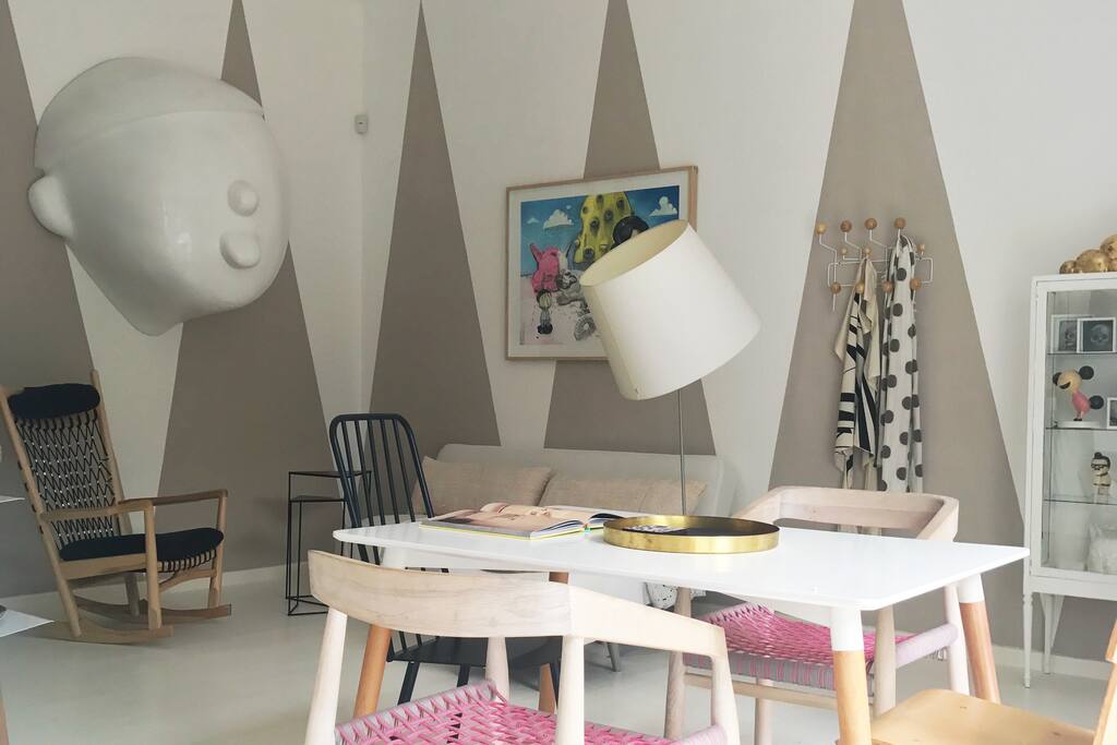 The lounge dinning room has a collection of art made by the owner with double volume doors opening the space to the outside courtyard.