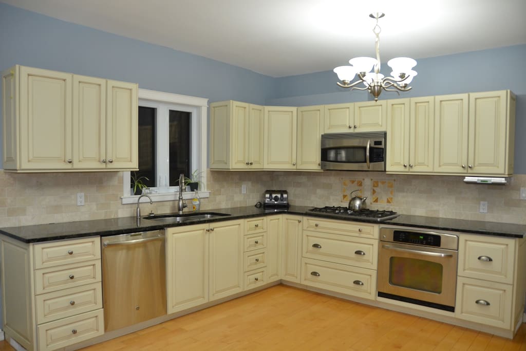 Open kitchen with stainless steel appliances, granite counter tops and custom millwork.