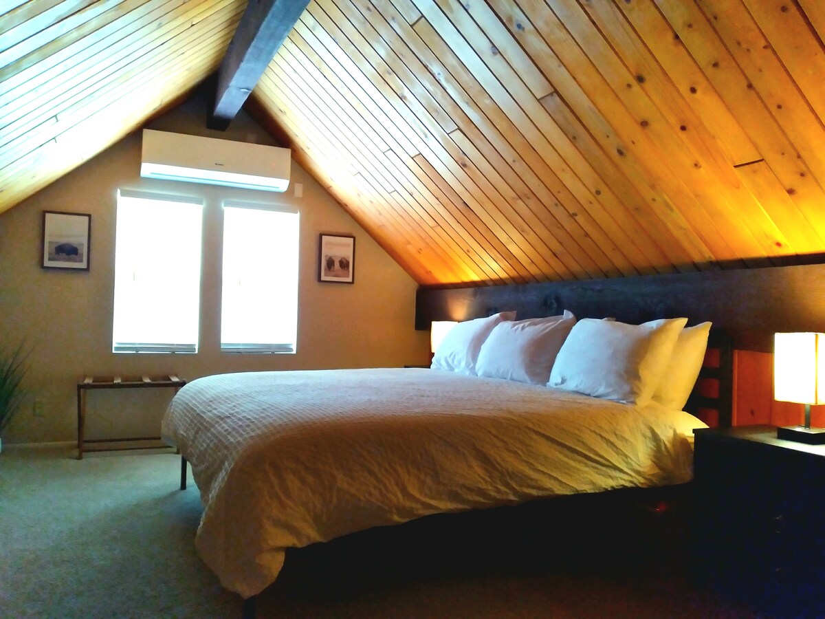 Spacious loft bedroom with king bed and a variety of pillows.  Mini split provide white noise and the perfect temperature for a blissful sleep.