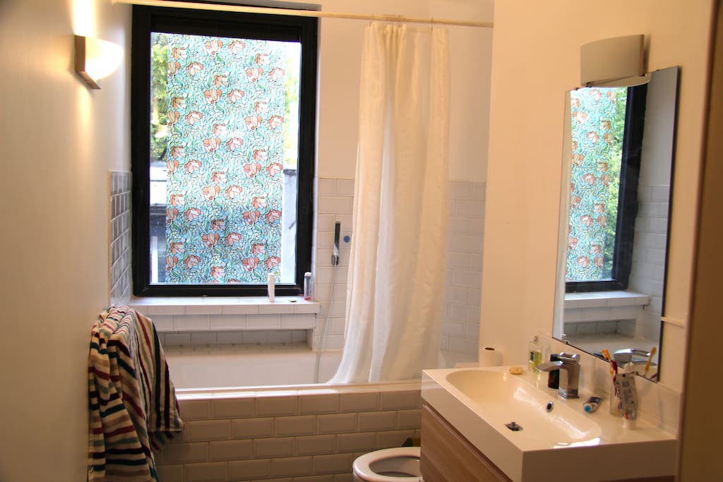 Full equiped bathroom with bathtub, shower and a big window