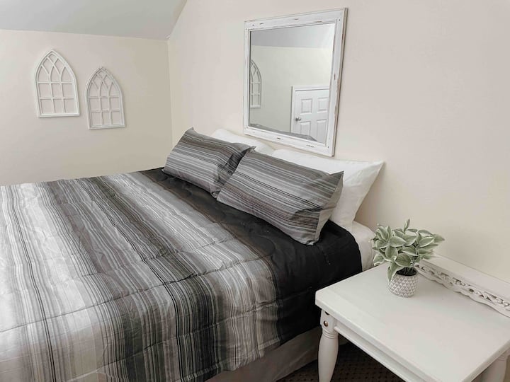 Upstairs guest bedroom with king-sized bed with half bath