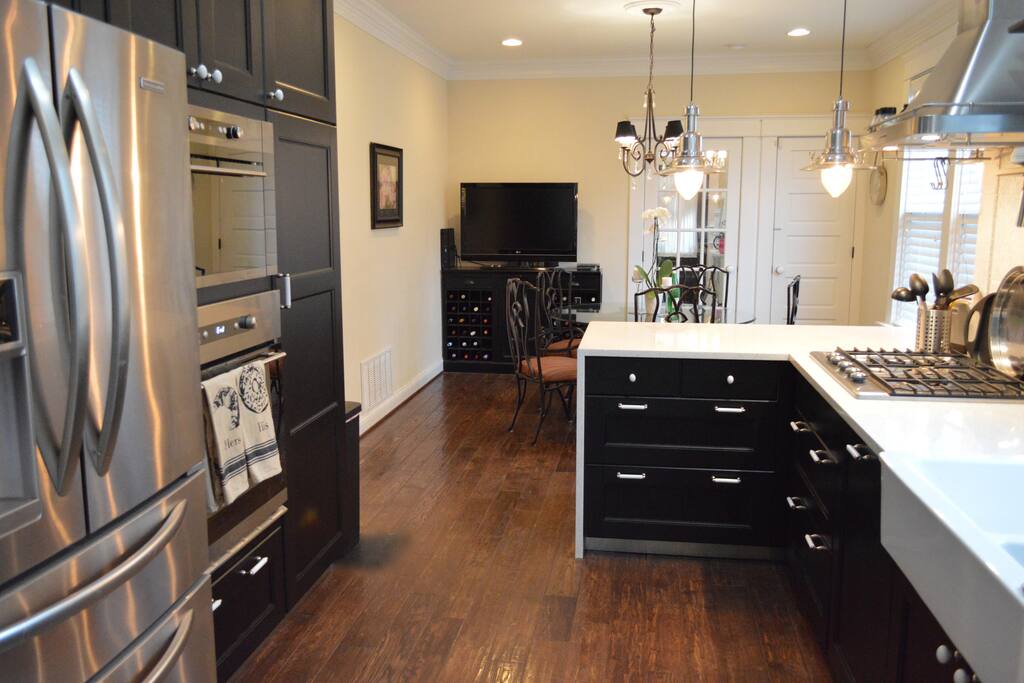 Kitchen Aid appliances and waterfall counter-top with bar chairs