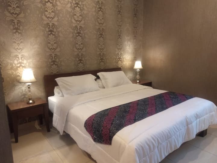 ห้องนอน #1 เตียงขนาดคิงไซส์พร้อมเครื่องปรับอากาศตู้เสื้อผ้าโต๊ะเครื่องแป้งและห้องอาบน้ำ ห้องนี้มีวิวสวน