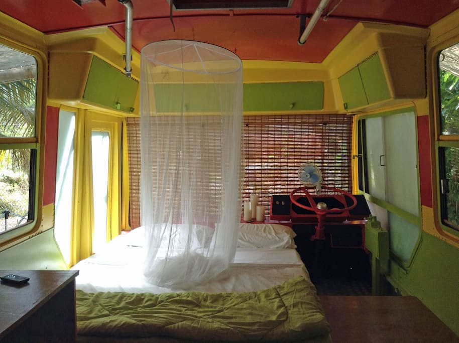 Front of bus and queen bed.