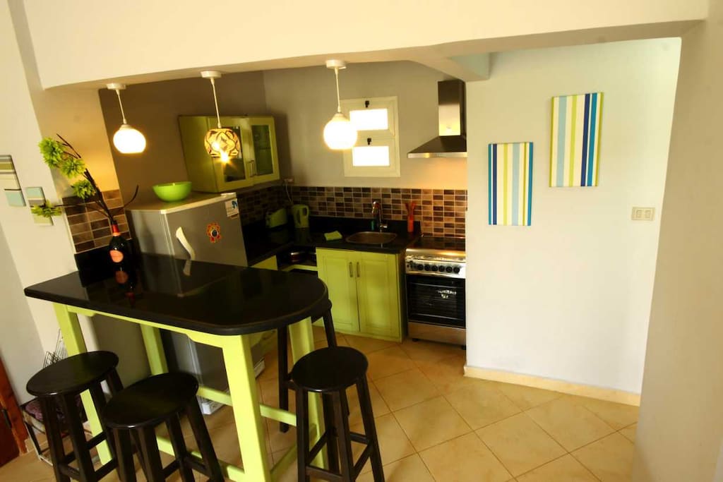 Open plan kitchen with gas oven, 4 hobs, extractor fan, kettle, toaster, large fridge/freezer.