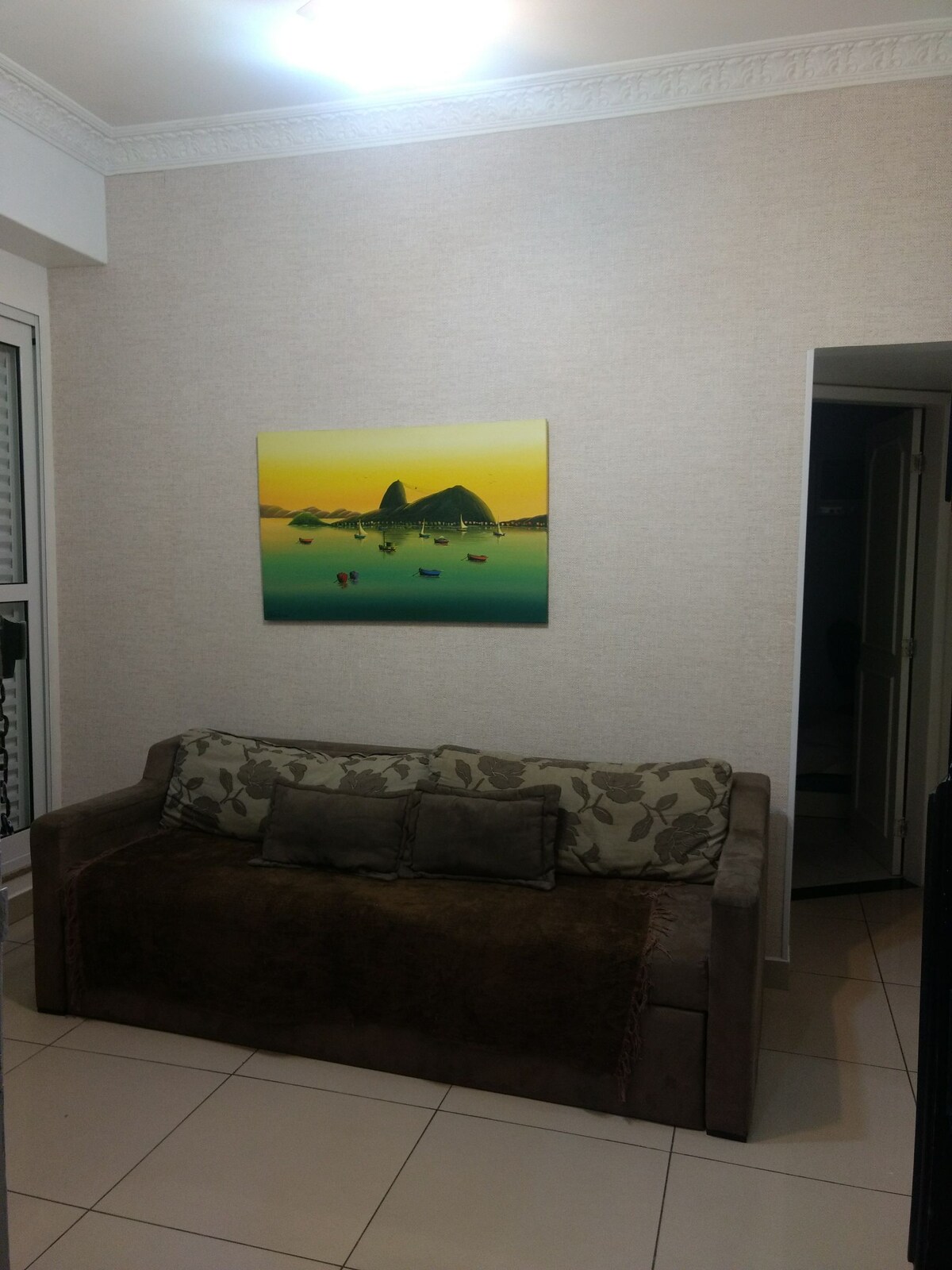 Фотографијата од дневната соба содржи тавански вентилатор и кауч на спуштање, покрај телевизорот.