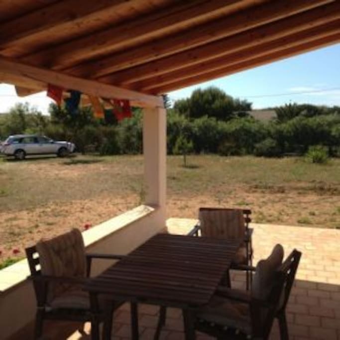 Veranda esterna con posto auto e giardino intorno.