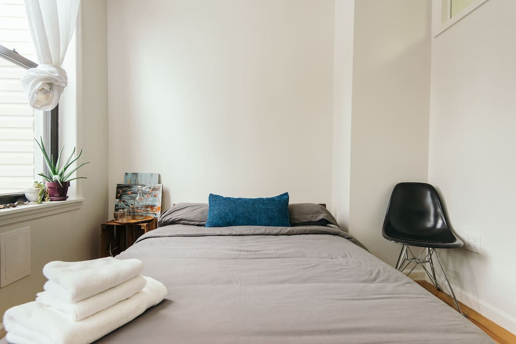 Your room, bright and cheery with soft comfy linens. Bed by Blue Dot and Eames chair :)