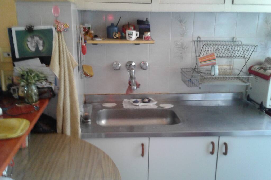 cocina con mesa-barra, lava y seca platos.