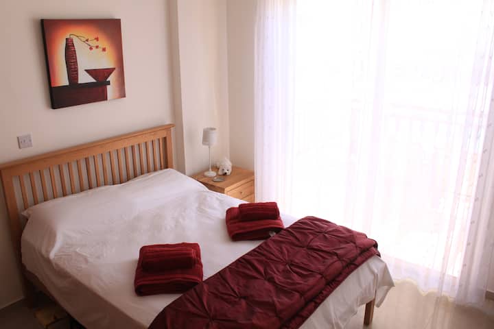 غرفة نوم مزدوجة مع خزانة ملابس مثبتة وأبواب مزدوجة على الشرفة المطلة على حمام السباحة.