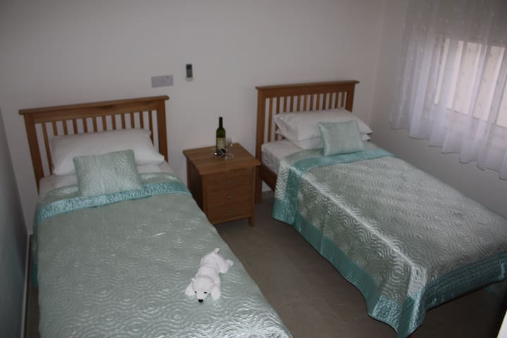 غرفة بسريرين مزدوجين مع خزانة ملابس مجهزة بالكامل.