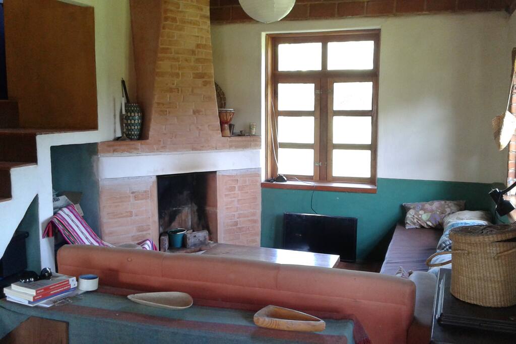 Sala espaciosa e iluminada con chimenea. Escalera al sanitario seco y a la segunda planta