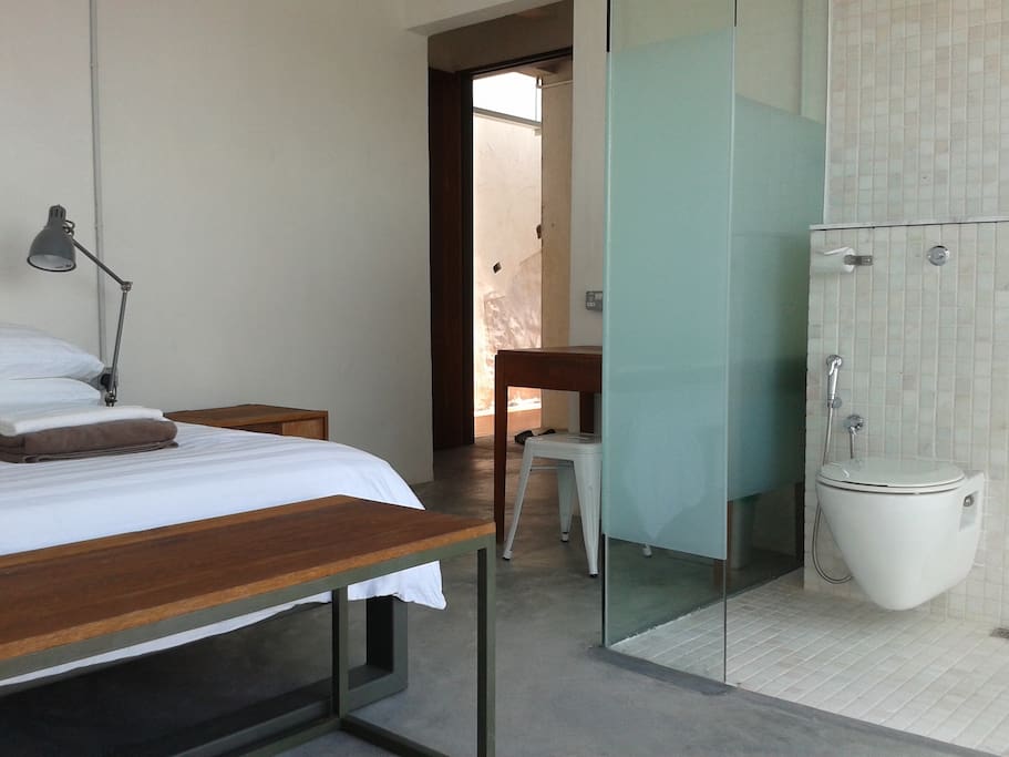 View of attached bathroom in relation to bed and entrance.