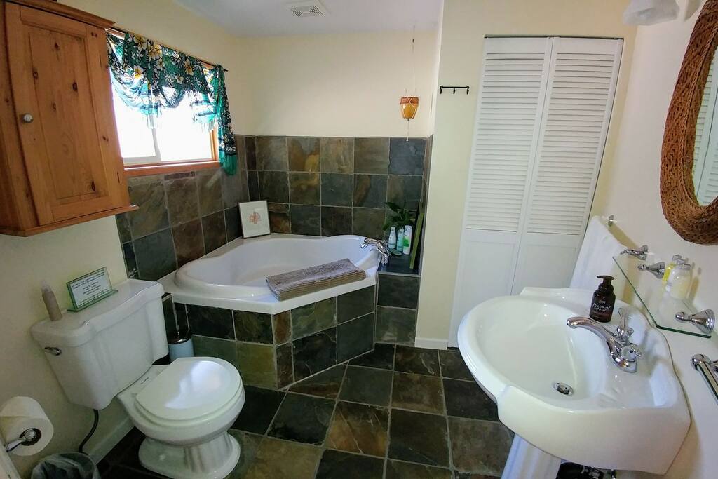 Large bathroom with heated slate floors and deep corner soaker tub