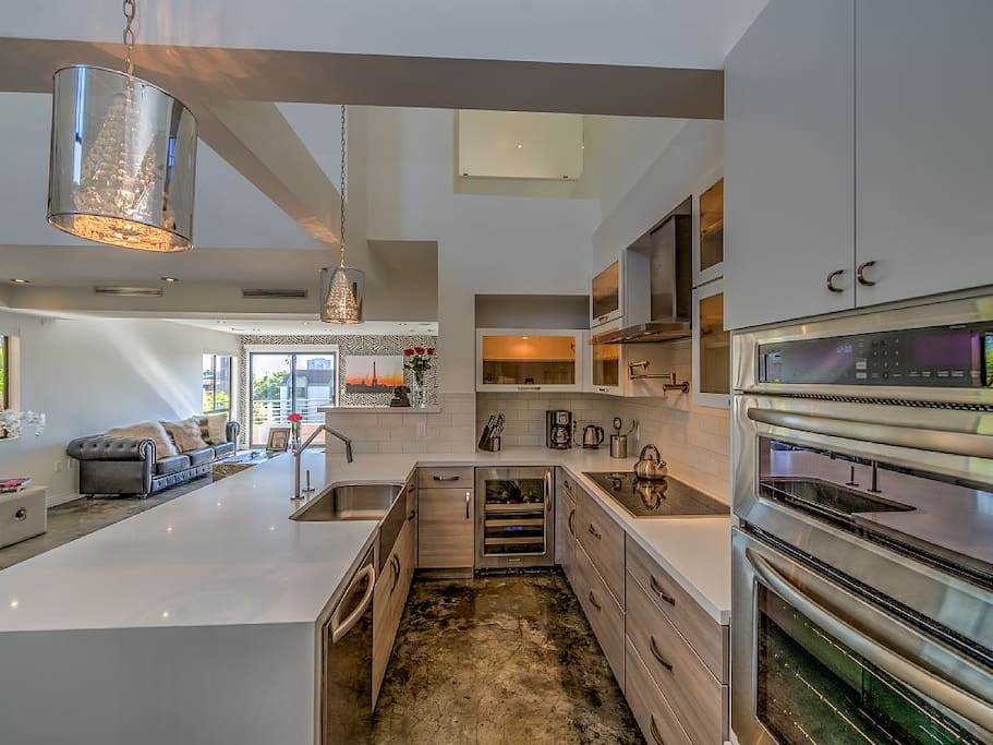 Chef's kitchen with quartz countertops and all amenities--wine cooler,dishwasher, stove, microwave, coffee maker, tea kettle, dishes, glassware, pots/pans, etc