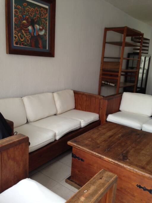 SALA DE MADERA CON COJINES DE TELA.