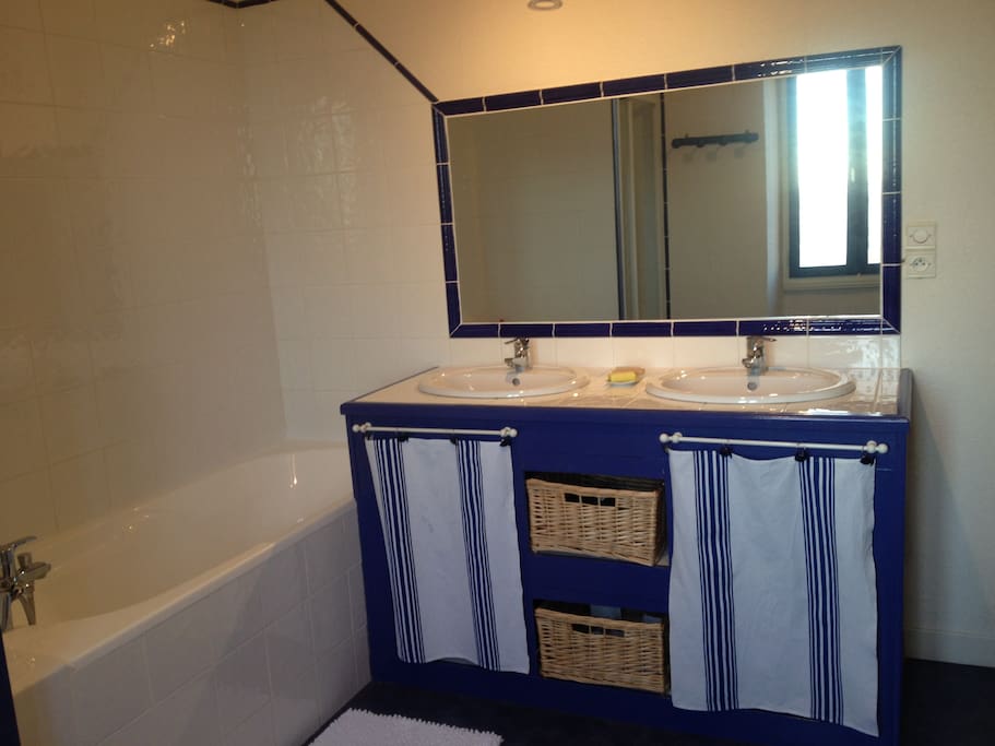 Une salle de bain avec double vasque, baignoire et douche