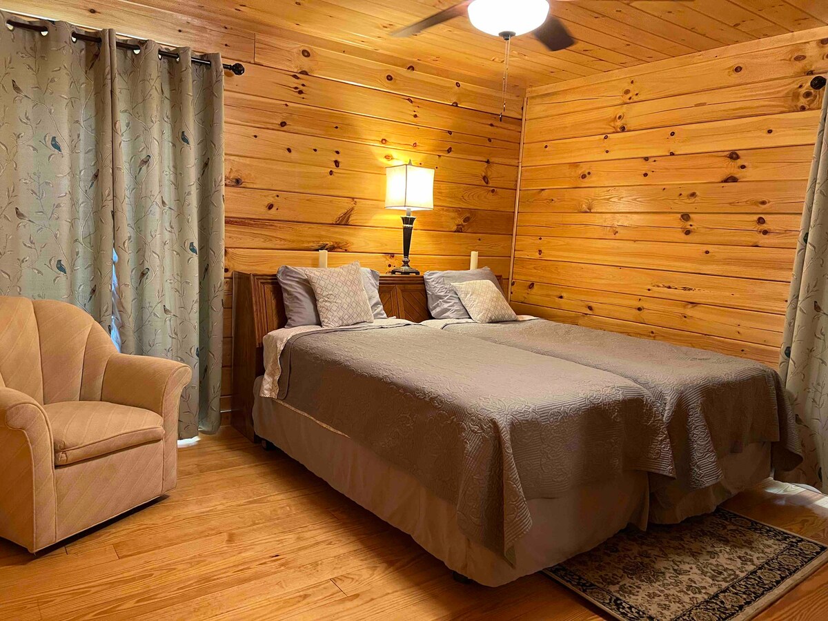 Twin bedroom with closet, chest, and headboard with charging outlets.