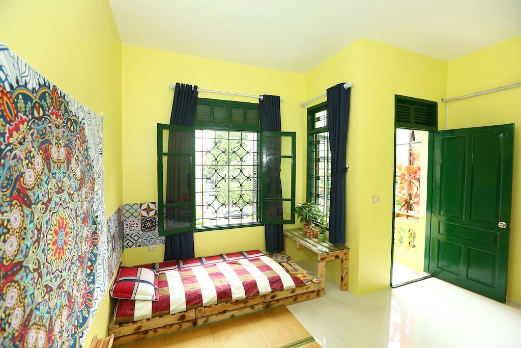 The yellow bed rooms. There are a double bed and a single bed in this room. There is also a private balcony from which you can look to the road. Two windows to welcome sunlight and fresh air.