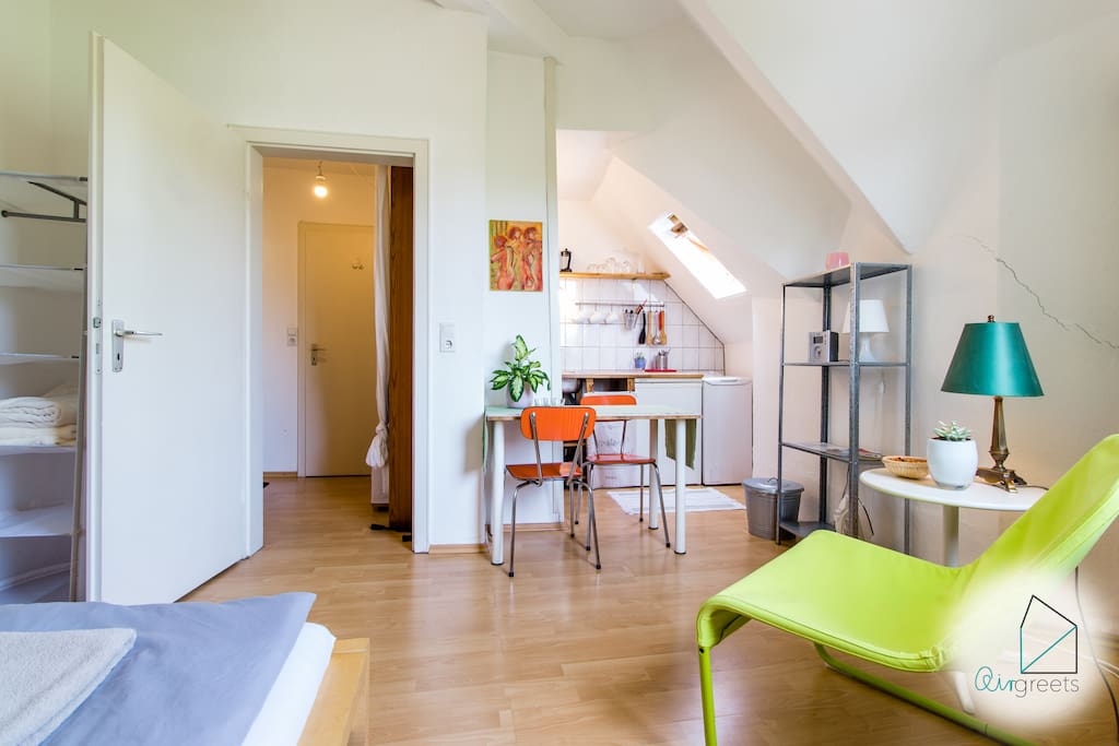 The studio apartment includes a sleeping area and a kitchen with a dining table.