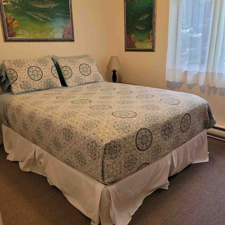 غرفة النوم الثانية في الطابق الرئيسي تضم سرير كوين وخزانتين